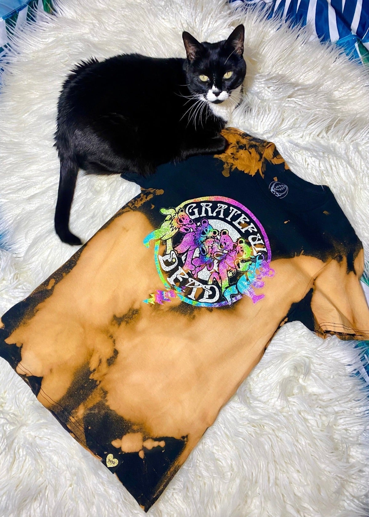 grateful dead bleach dye t shirt on a white furry background with black and white car