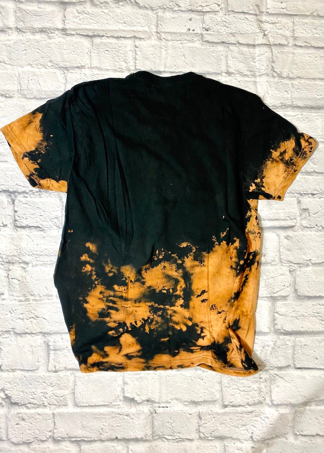 back of bleach dyed wu tang clan t shirt on a white brick background