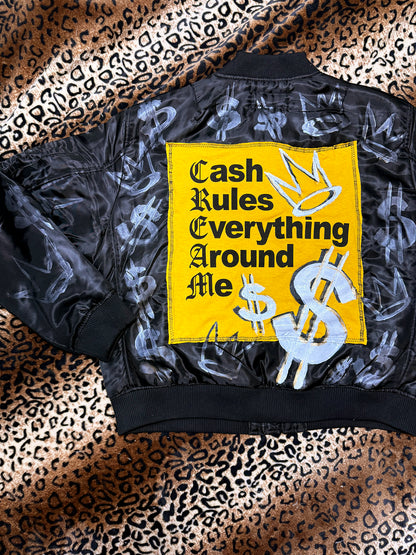 Black jacket with a yellow patch featuring text and dollar signs on a leopard print background