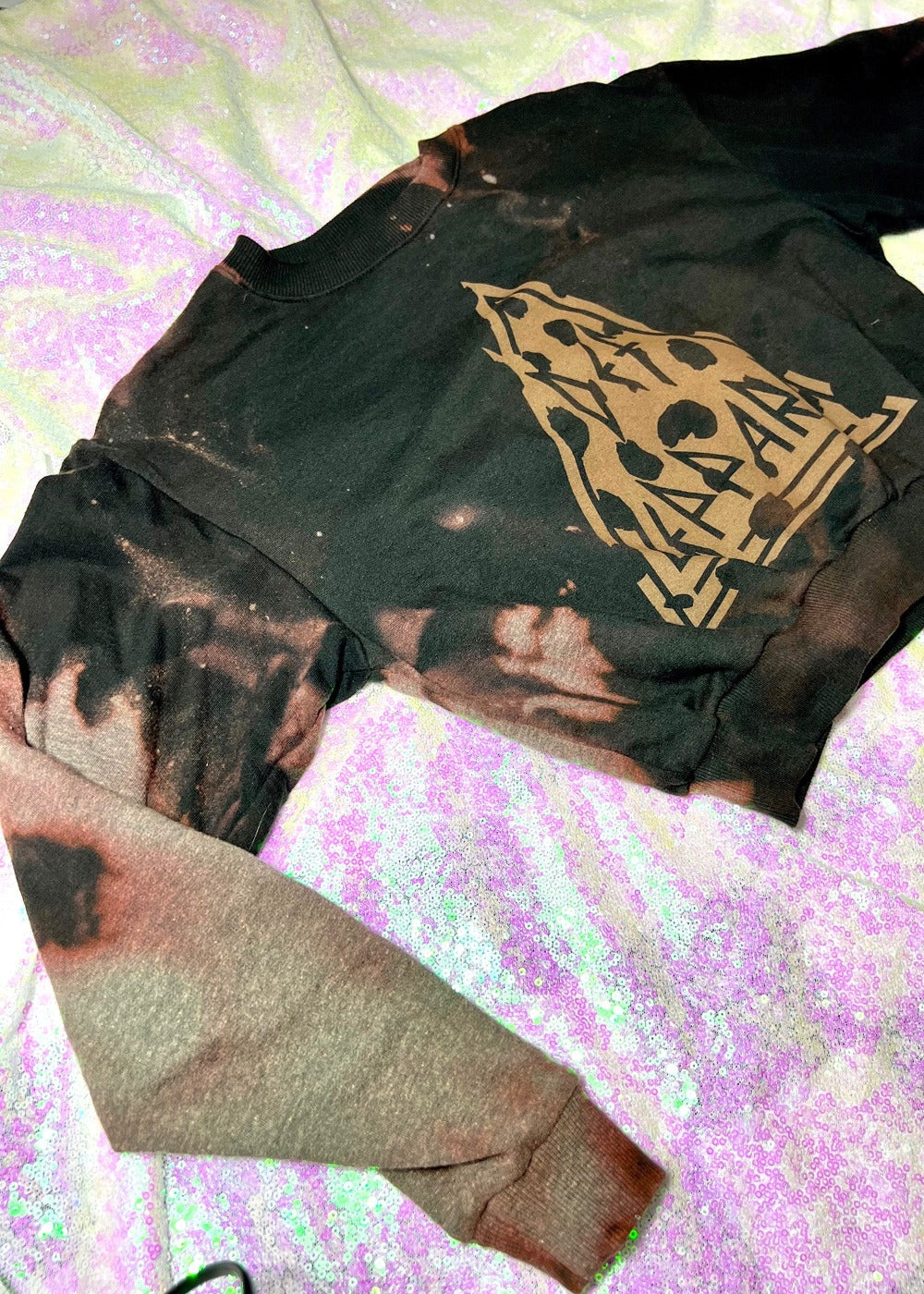 def leppard bleach dye sweatshirt on a sequin background close up