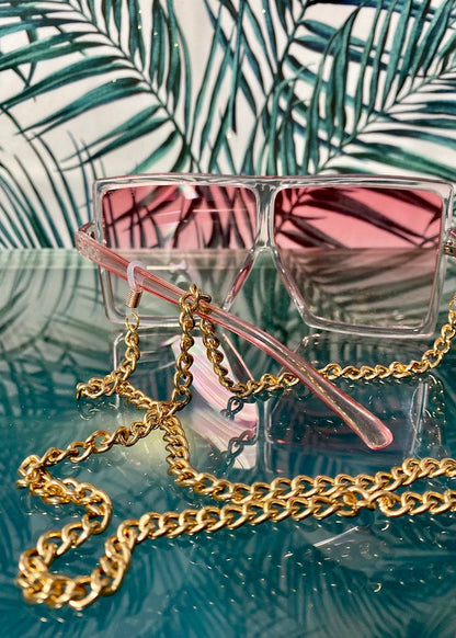 thick gold eyeglass chain on glass surface