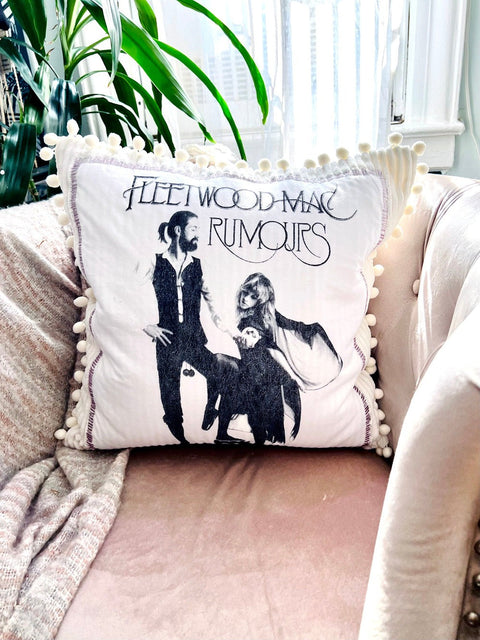 fleetwood mac throw pillow on blush colored chair with plant in the background close view