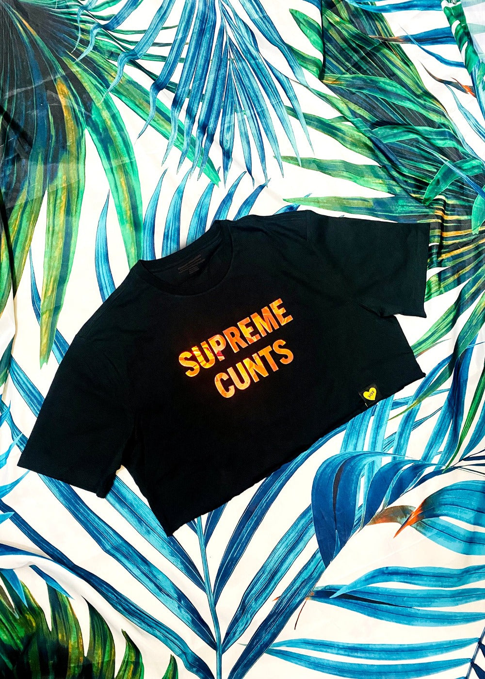 black graphic crop t shirt on a palm background full view